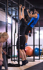 Image showing young athletes doing pull ups on the horizontal bar