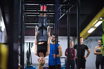 Image showing woman working out with personal trainer on gymnastic rings