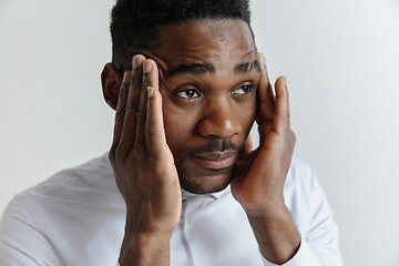 Image showing Stressed young african american man having terrible strong headache.