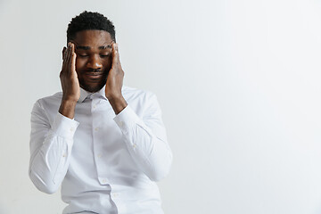 Image showing Stressed young african american man having terrible strong headache.