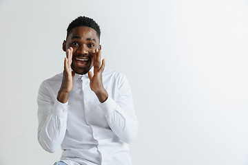 Image showing Wow. Attractive male half-length front portrait on grey studio backgroud. Young afro emotional surprised bearded man standing with open mouth. Human emotions, facial expression concept.