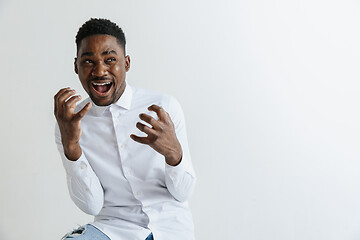 Image showing Wow. Attractive male half-length front portrait on grey studio backgroud. Young afro emotional surprised bearded man standing with open mouth. Human emotions, facial expression concept.