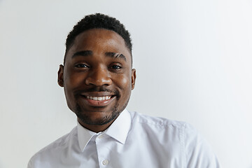 Image showing Close up portrait of a happy young african american man laughing against gray background.