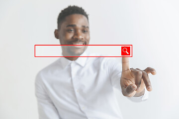 Image showing Young african american guy interacts with empty search bar. Negative space to insert your text.