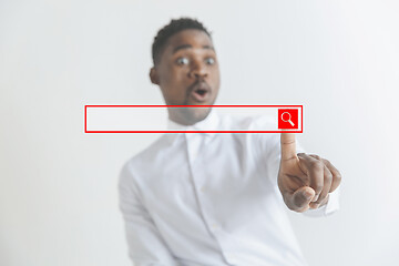 Image showing Young african american guy interacts with empty search bar. Negative space to insert your text.