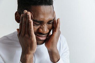 Image showing Stressed young african american man having terrible strong headache.