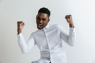 Image showing Wow. Attractive male half-length front portrait on grey studio backgroud. Young afro emotional surprised bearded man standing with open mouth. Human emotions, facial expression concept.