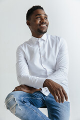 Image showing Close up portrait of a happy young african american man laughing against gray background.