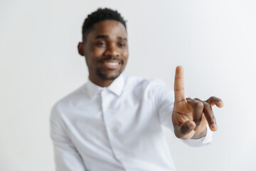 Image showing Young african american guy interacts with empty space. Negative space to insert your text or image.