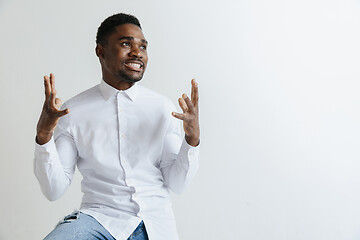 Image showing Close up portrait of a happy young african american man laughing against gray background.