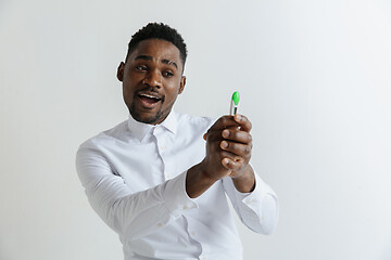 Image showing Young happy african american man looking at pregnancy test. Handsome smiling man inspired and delighted. Guy pleased because of result of pregnancy test.