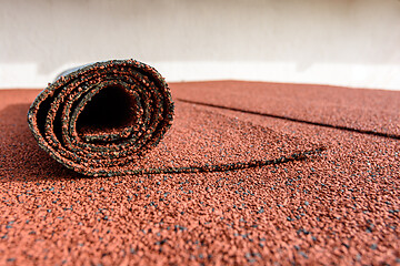 Image showing Bitumen roll shingles are laid on the roof on which a roll of shingles lies