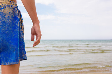 Image showing Man in blue shorts on the seashore, fragment with seascape