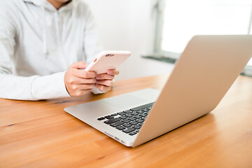 Image showing Woman using laptop computer and cellphone at home