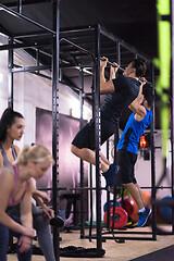 Image showing young athletes doing pull ups on the horizontal bar