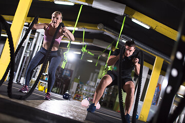 Image showing sports couple doing battle ropes cross fitness exercise