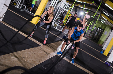 Image showing sports couple doing battle ropes cross fitness exercise