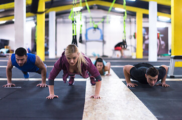 Image showing young healthy people doing pushups