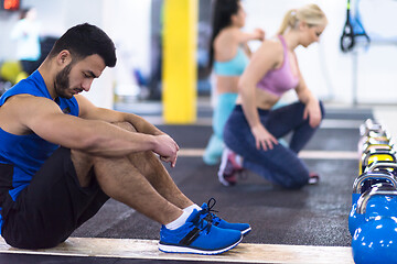 Image showing young athletes doing pushups with kettlebells