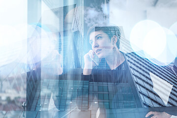 Image showing Elegant Woman Using Mobile Phone by window in office building