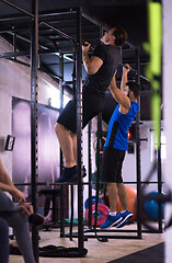 Image showing young athletes doing pull ups on the horizontal bar