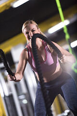 Image showing athlete woman doing battle ropes cross fitness exercise