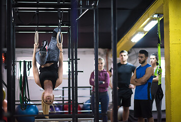 Image showing woman working out with personal trainer on gymnastic rings