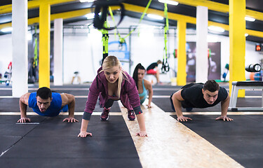 Image showing young healthy people doing pushups