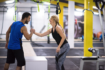 Image showing woman working out with personal trainer jumping on fit box