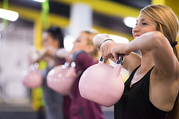 Image showing athletes doing exercises with kettlebells