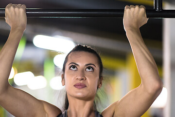 Image showing woman doing pull ups on the horizontal bar