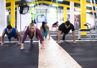 Image showing young healthy people doing pushups