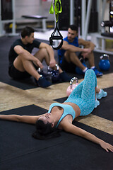 Image showing young athlete woman lying on the floor and relaxing