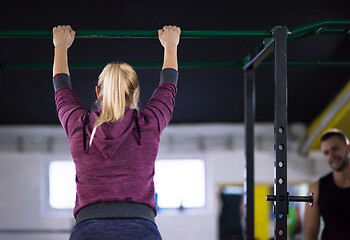 Image showing woman doing pull ups on the horizontal bar