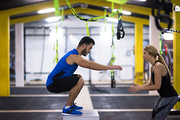 Image showing woman working out with personal trainer jumping on fit box