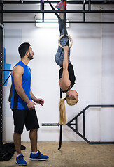 Image showing woman working out with personal trainer on gymnastic rings