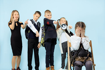 Image showing Little girl sitting alone on chair and suffering an act of bullying.