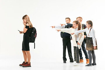 Image showing Little girl standing alone and suffering an act of bullying.