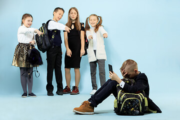 Image showing Little boy sitting alone on floor and suffering an act of bullying.