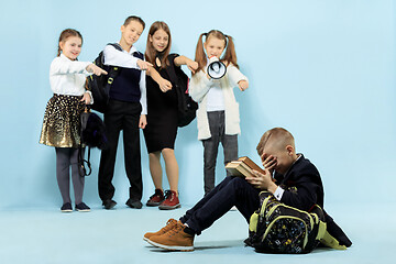 Image showing Little boy sitting alone on floor and suffering an act of bullying.