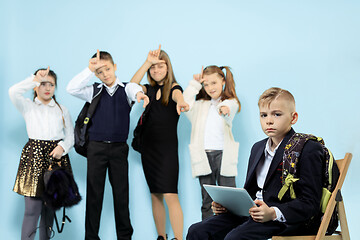 Image showing Little boy sitting alone on chair and suffering an act of bullying.