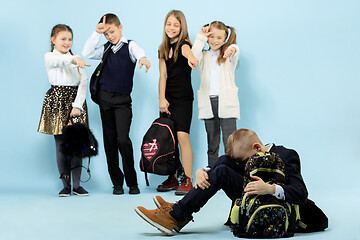 Image showing Little boy sitting alone on floor and suffering an act of bullying.