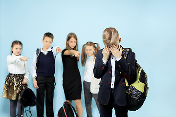 Image showing Little boy standing alone and suffering an act of bullying.