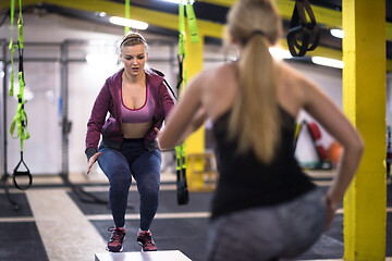 Image showing athletes working out  jumping on fit box