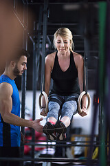 Image showing woman working out with personal trainer on gymnastic rings
