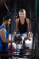 Image showing woman working out with personal trainer on gymnastic rings