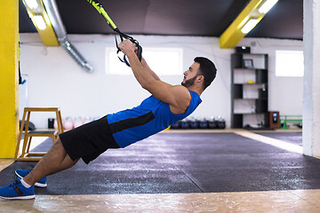 Image showing man working out pull ups with gymnastic rings