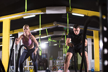 Image showing sports couple doing battle ropes cross fitness exercise