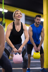 Image showing athletes doing exercises with kettlebells