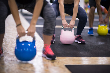 Image showing athletes doing exercises with kettlebells